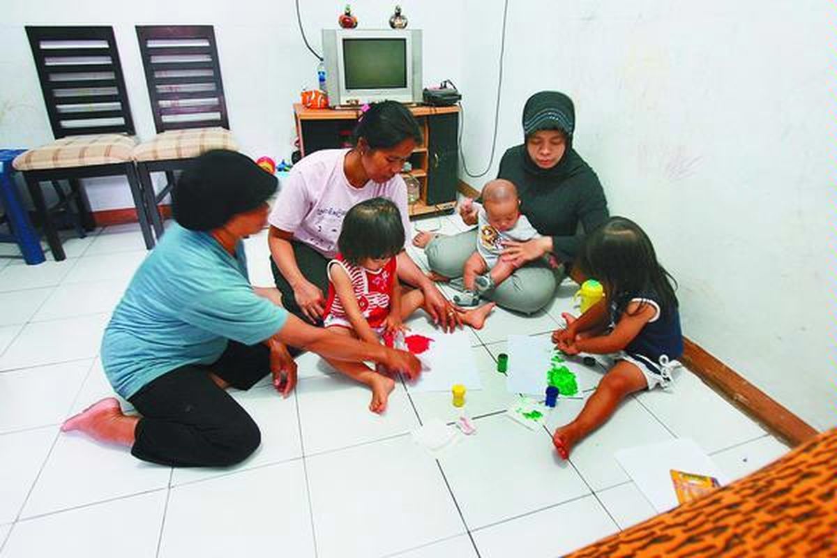 Tita (kanan, berjilbab) merasa lebih aman mengambil pengasuh dari daerah asalnya, Temanggung, Jawa Tengah.