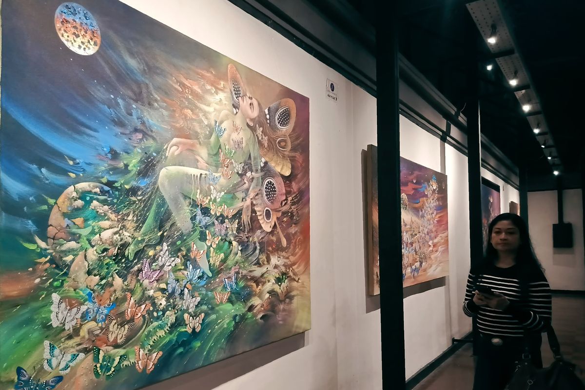 Seorang pengunjung menyaksikan lukiasan hasil karya pameran tunggal pelukis asal Surabaya Buggy Budiyanto dalam rangka memperingati Hari Kebangkitan Nasional di Galeri Dewan Kesenian Surabaya, Selasa (20/5/2025) malam.