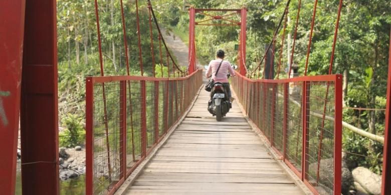 Pengunjung melintasi jembatan di Sungai Gelar, Kabupaten Jembrana, salah satu tempat wisata di Bali Barat.