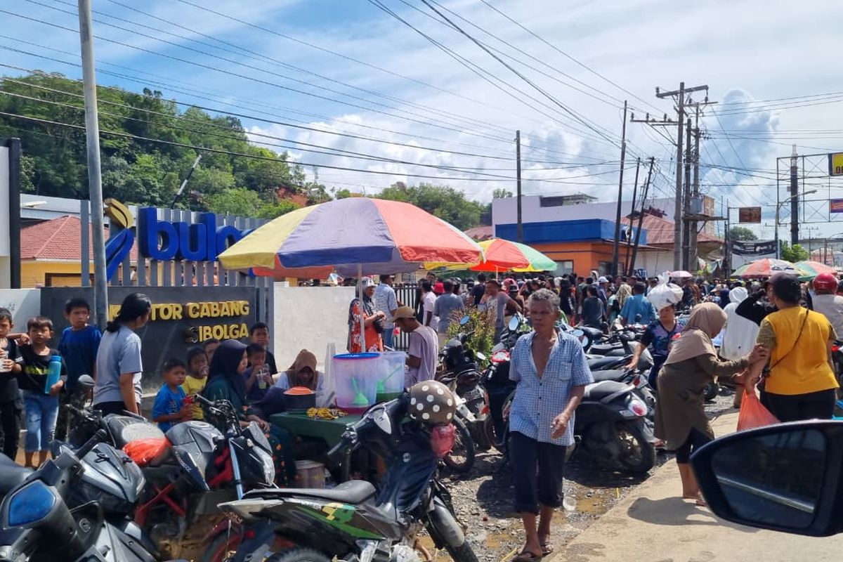 Antrean warga mengular untuk mendapatkan bantuan beras di Kantor Bulog Kota Sibolga, Kabupaten Tapanuli Tengah, Sumatera Utara pada Kamis (4/12/2025) siang.