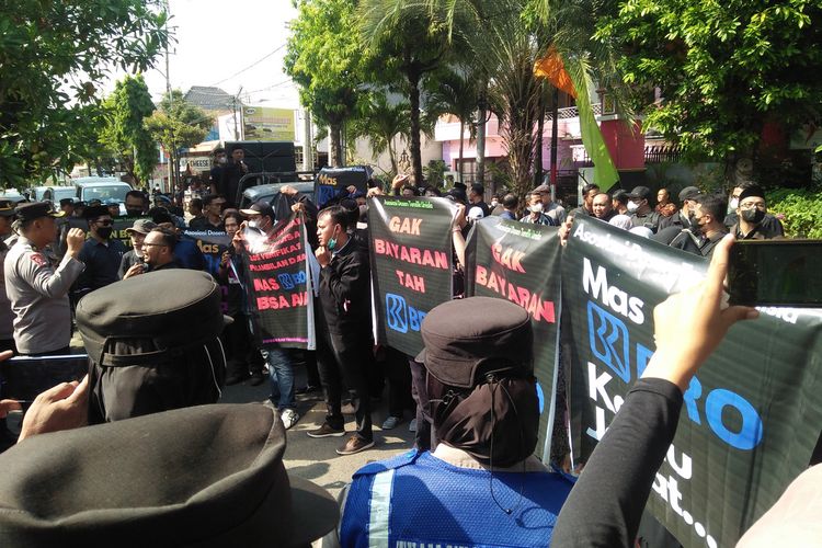 Puluhan dosen, petugas teknik dan karyawan Universitas Islam Lamongan (Unisla), saat menggelar unjuk rasa di depan kantor BRI cabang Lamongan, Jawa Timur, Senin (19/6/2023).