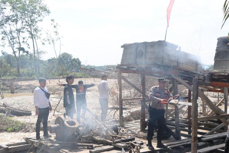 Petugas kepolisian membakar rakit tambang emas ilegal di Kabupaten Kuantan Singingi, Riau, Selasa (16/5/2023).