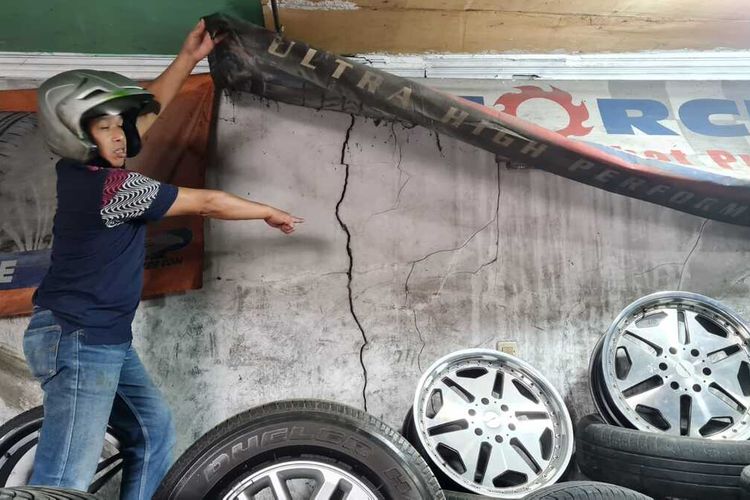 Sejumlah warga menunjukkan kerusakan rumah dan toko mereka akibat dampak pembangunan proyek Jembatan Cikereteg, Desa Ciderum, Kecamatan Caringin, Kabupaten Bogor, Jawa Barat, Senin (22/5/2023). Toko dan rumah warga retak-retak akibat getaran alat berat.