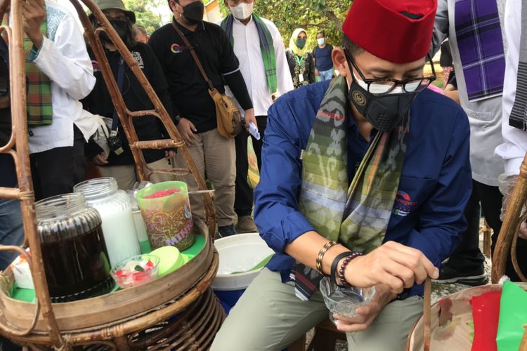 Menteri Pariwisata dan Ekonomi Kreatif, Sandiaga Uno menjajal jadi penjual es selendang mayang di Kawasan Perkampungan Betawi Setu Babakan, Ciganjur, Jagakarsa, Jakarta Selatan pada Jumat (3/9/2021) siang.