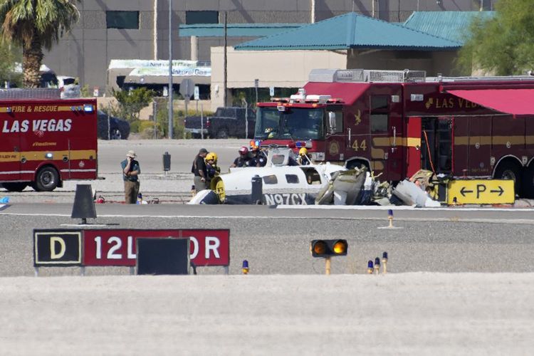 Petugas menyelidiki puing-puing pesawat di lokasi kecelakaan fatal di Bandara North Las Vegas, Minggu (17/7/2022). Pihak berwenang mengatakan sedikitnya empat orang tewas setelah dua pesawat bertabrakan di bandara Las Vegas.  