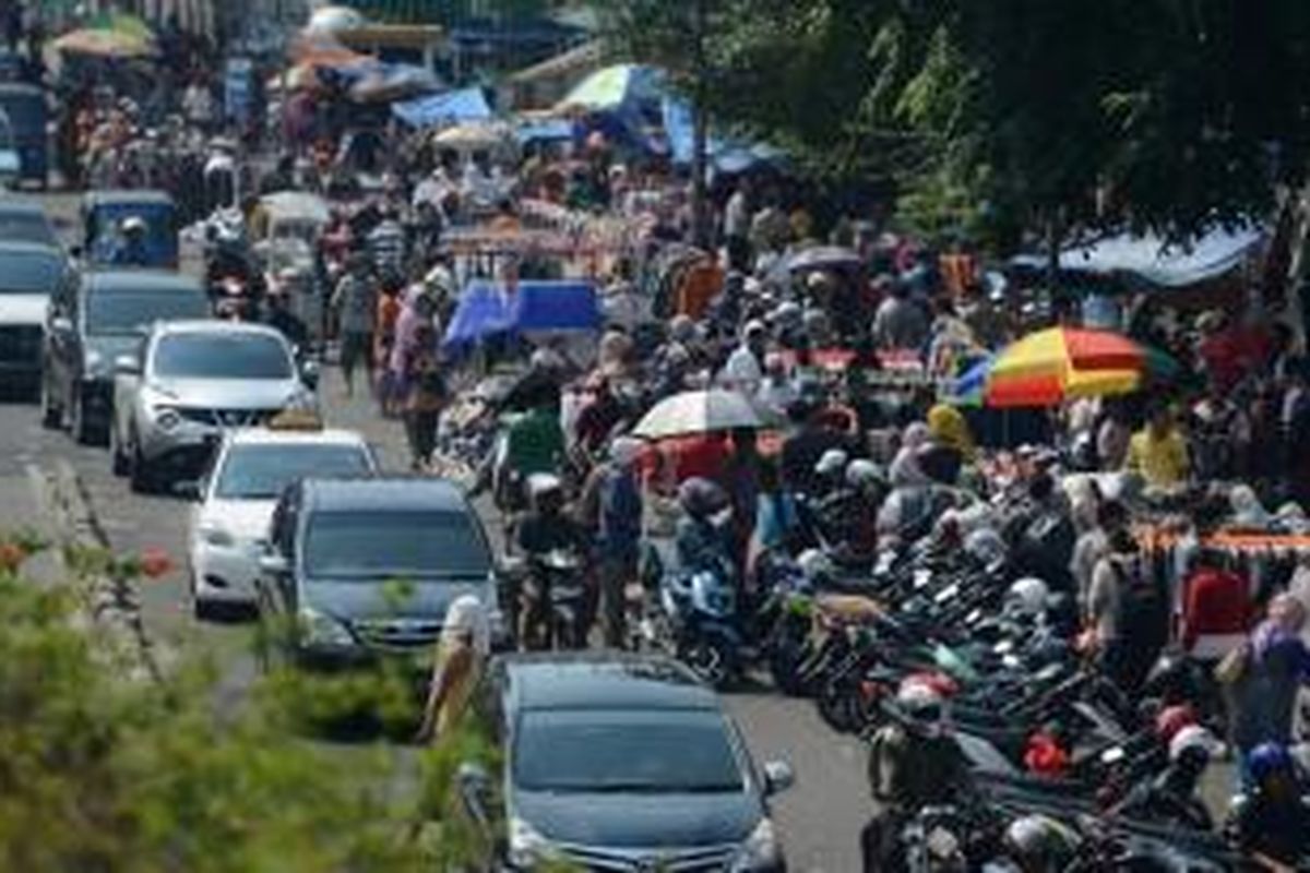 Lalu lintas tersendat di ruas jalan di depan pusat perdagangan Pasar Senen, Jakarta, Senin (28/4/2014). Pascakebakaran beberapa hari lalu, ratusan pedagang terpaksa berjualan dengan memakan badan jalan sehingga menambah keruwetan jalan di sekitar pasar.