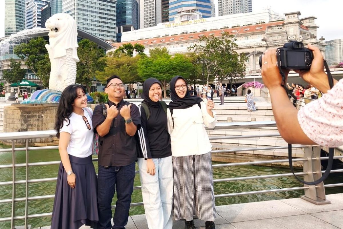 Wisatawan asal Indonesia berfoto di ikon Singapura, Merlion Park, pada Jumat (18/9/2026). 