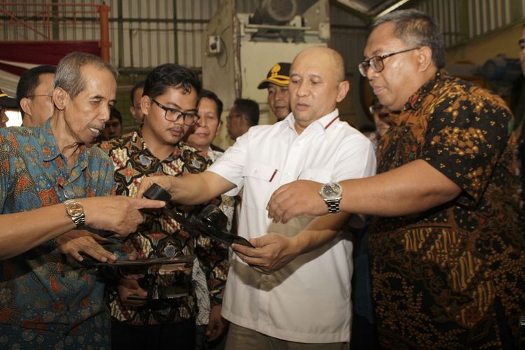 Menteri Koperasi dan UKM Teten Masduki (kanan kedua) didampingi Bupati Sukabumi Marwan Hamami (kanan) melihat-lihat cangkul buatan Cibatu, Kecamatan Cisaat di Sukabumi, Jawa Barat, Sabtu (23/11/2019).