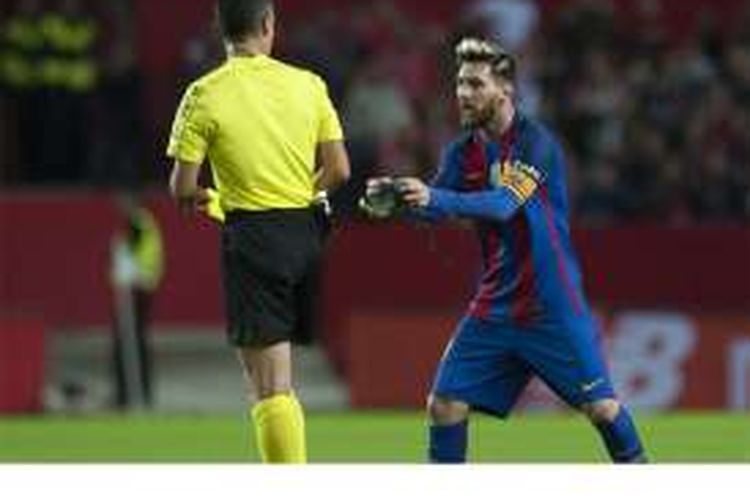 Penyerang Barcelona, Lionel Messi (kanan), memperlihatkan sepatunya kepada wasit setelah diganjar kartu kuning pada pertandingan La Liga melawan Sevilla di Stadion Ramon Sanchez Pizjuan, Sevilla, Minggu (6/11/2016).