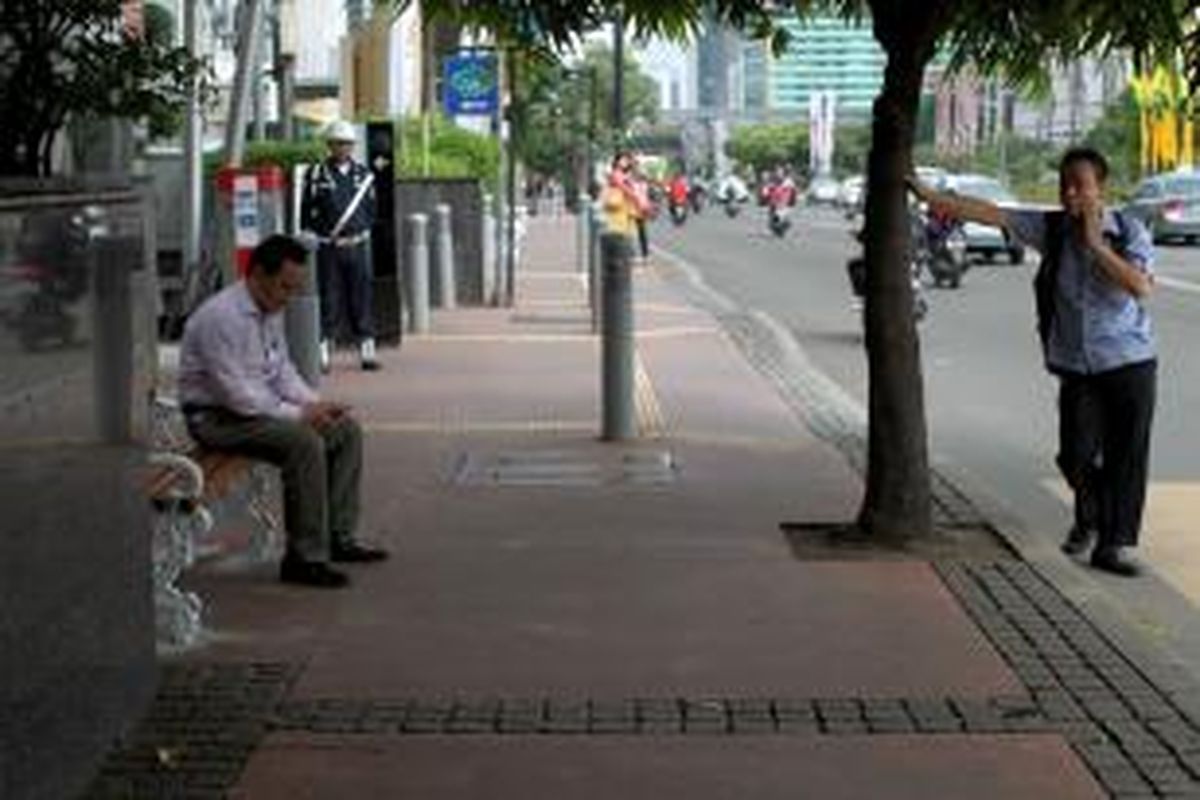 Warga duduk di bangku taman yang terpasang sejak semalam di kawasan Jalan MH Thamrin, Jakarta, Rabu (19/6/2013). Sebanyak 340 unit bangku taman dipasang di Jalan Sudirman, Jalan MH Thamrin hingga kawasan Medan Merdeka untuk memberikan kenyamanan kepada pengguna trotoar di Jakarta.