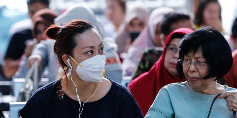 Calon penumpang kereta api mengenakan masker di Stasiun Gambir, Jakarta, Jumat (31/1/2020). PT KAI Daop 1 Jakarta membagikan masker gratis pada calon penumpang dalam rangka mengantisipasi penyebaran virus corona.