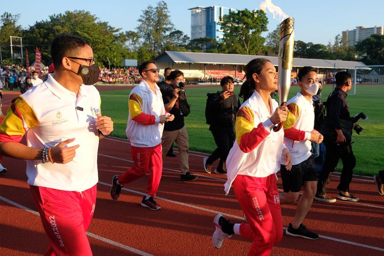 Menteri Pariwisata dan Ekonomi Kreatif Indonesia, Sandiaga Uno (paling kiri), dan Wali Kota Surakarta, Gibran Rakabuming Raka (dua dari kanan), beserta para artis Ibu Kota saat mengikuti pawai obor ASEAN Para Games 2022 di Stadion Sriwedari, Solo, pada Minggu (24/7/2022).