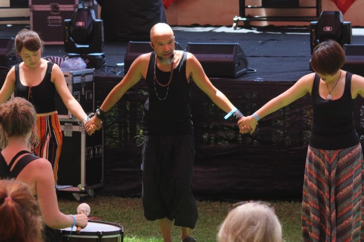 Para peserta Bali Spirit Festival sedang bergandengan tangan saat mengikuti salah satu rangkaian kegiatan di event tersebut. 