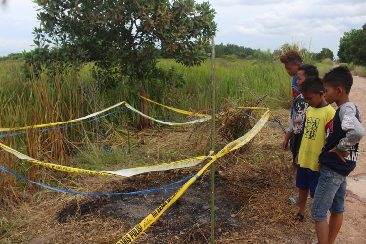 Lokasi tempat penemuan jenazah IA (20) korban pembunuhan yang tewas dibakar di Jalan Kebun Sawit Dusun IV SP 2 Desa Sungai Rambutan Kecamatan Indralaya Utara Kabupaten Ogan Ilir, Minggu (20/1/2019).