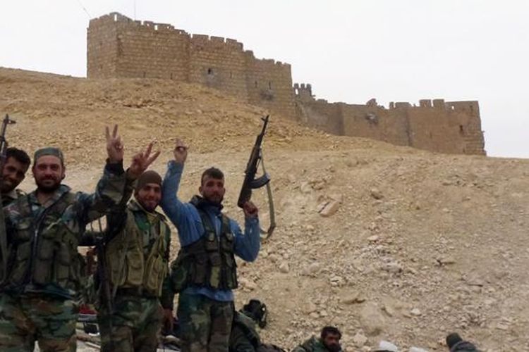 Sekelompok prajurit Suriah merayakan kesuksesan mereka merebut kembali kota Palmyra dari tangan ISIS, Minggu (27/3/2016).
