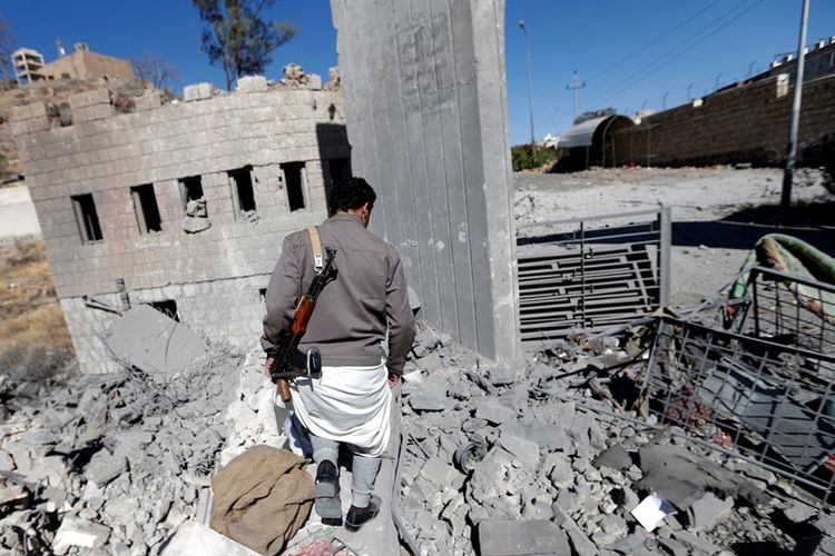 Seorang pejuang Houthi mengamati gedung televisi Al-Masirah yang hancur akibat serangan udara Arab Saudi dan sekutunya. Serangan tersebut menewaskan empat penjaga yang tengah tertidur (9/12/2017).