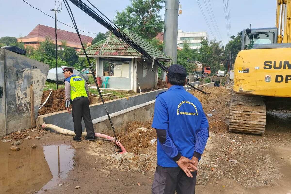 Tiang kabel utilitas di Jalan Pemuda, Pulogadung, Jakarta Timur, jatuh, diduga akibat saluran air longsor, Selasa (17/3/2020).