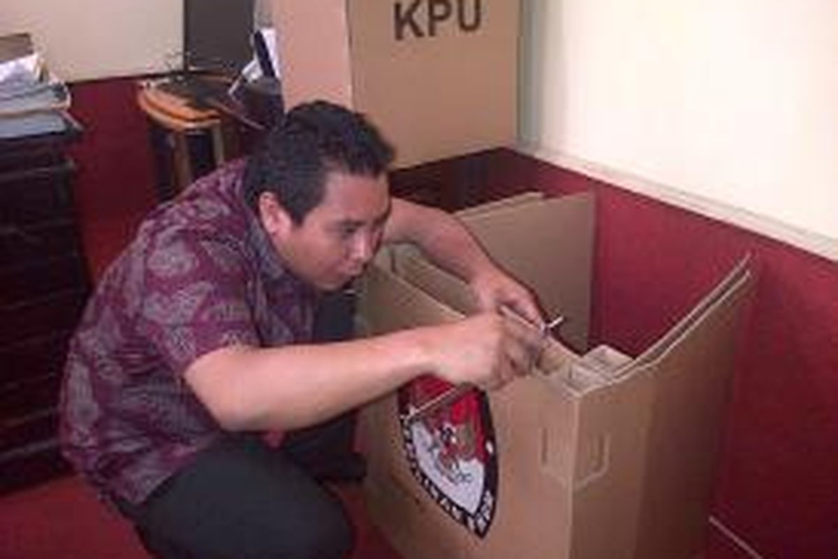 Ketua KPU Sultra mengukur ketebalan bilik suara yang terbuat dari kardus yang tak sesuai spesifikasi, padahal logistik itu akan digunakan pada pemilu 2014 mendatang