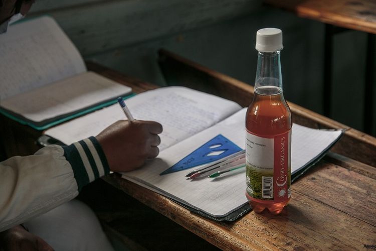 Sebotol Covid Organics, teh herbal, yang digembar-gemborkan oleh Presiden Madagaskar Andry Rajoelina sebagai obat kuat melawan virus corona, yang diberikan kepada setiap siswa dan mendorong mereka untuk meminumnya sebelum dimulainya kelas terlihat di meja siswa. 
Lokasi: JJ Rabearivelo High School di pusat kota Antananarivo pada 23 April 2020. 