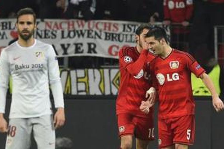 Gelandang Bayer Leverkusen, Hakan Calhanoglu (tengah), merayakan golnya bersama Emir Spahic (kanan) ke gawang Atletico Madrid pada laga leg pertama babak 16 besar Liga Champions di BayArena, Leverkusen, Rabu (25/2/2015).