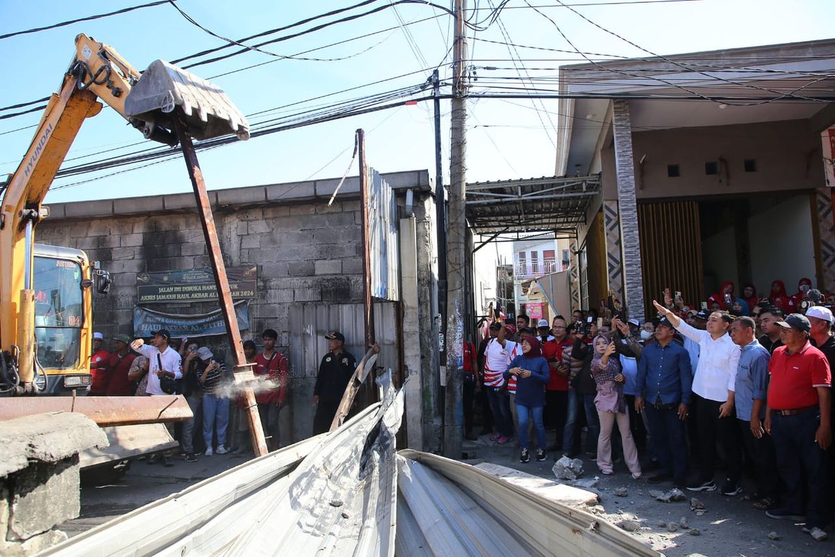 Tembok yang menutupi Jalan Tambak Wedi Baru, Kenjeran, menuju Jalan Dukuh Bulak Banteng, Surabaya, dibongkar menggunakan alat berat setelah enam tahun lamanya ditutup, Jumat (13/9/2024).