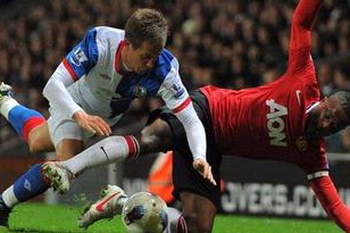 Defender Manchester United, Patrice Evra (kanan) berebut bola dengan pemain Blackburn Rovers, Morten Gamst Pedersen, pada lanjutan Premier League, Senin atau Selasa (3/4/2012) dini hari WIB. MU akhirnya menang 2-0 berkat gol Antonio Valencia dan Ashley Young.