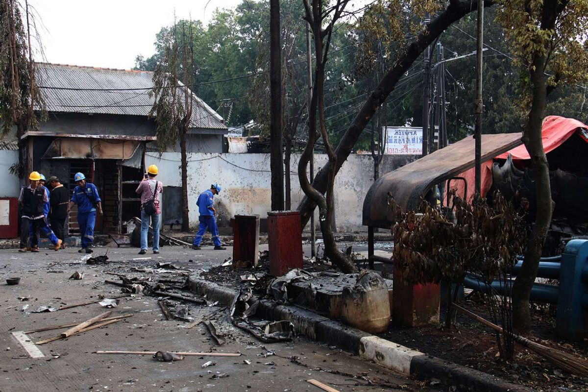 Petugas memeriksa lokasi kejadian terbakarnya truk tangki di SPBU Jalan Kahfi 2, Jagakarsa, Jakarta, Sabtu (30/12/2017). Kebakaran diduga karena ada percikan api saat proses pengisian bensin ke kilang SPBU pada Jumat (29/12/2017), pukul 22.25 WIB.