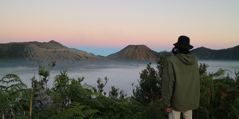 Wisatawan menikmati pemandangan saat berburu matahari terbit dari Bukit Mentigen, Cemoro Lawang, Desa Ngadisari, Sukapura, Probolinggo, Jawa Timur. Bukit Mentigen adalah salah satu alternatif tempat melihat matahari terbit selain Bukit Penanjakan di Taman Nasional Bromo Tengger Semeru.