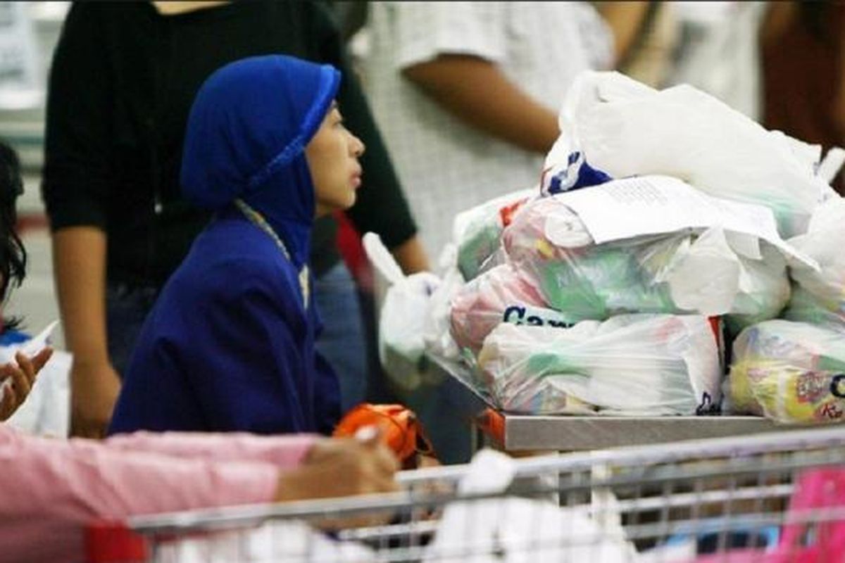 Pembeli bersiap membawa belanjaan mereka yang dibungkus kantong plastik di sebuah pasar swalayan di Jakarta.