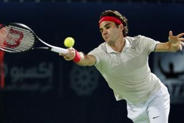 Petenis Swiss Roger Federer mengembalikan bola ke arah petenis Ceko Lukas Rosol pada laga perempat final Dubai Duty Free Tennis Championships, Kamis (27/2/2014).