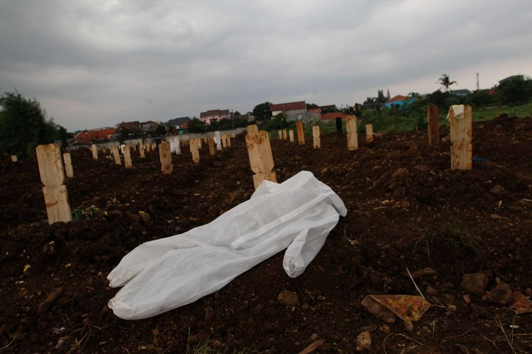 Baju APD petugas pemakaman terlihat di samping makam penderita Covid-19 di TPU Srengseng Sawah, Jakarta Selatan, Senin (25/1/2021). Berdasarkan data Satgas Penanganan Covid-19, terdapat 9.994 kasus baru dalam 24 jam terakhir. Jumlah pasien Covid-19 di Indonesia hingga hari ini 999.256 orang, terhitung sejak pengumuman pasien pertama pada 2 Maret 2020.