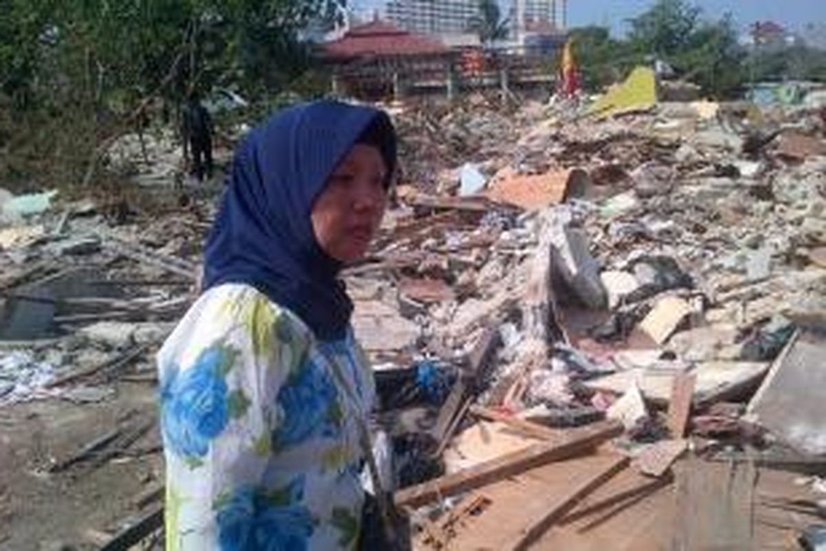 Hawaria (46) tertunduk lesu ketika kembali melihat bangunan rumahnya yang sudah menjadi puing, di kawasan Terminal Depok, Jumat (10/10/2014) sore.