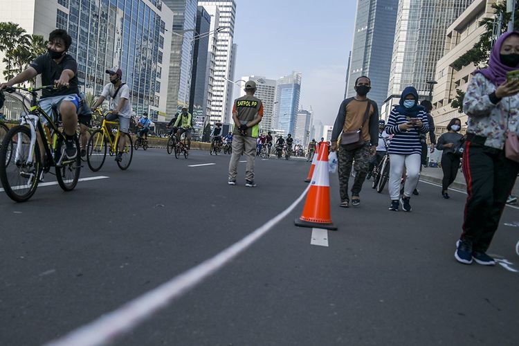 Warga berolahraga saat hari bebas berkendara atau car free day (CFD) di kawasan Jalan MH Thamrin, Jakarta, Minggu (21/6/2020). Dinas Perhubungan (Dishub) Provinsi DKI Jakarta memisahkan jalur untuk pesepeda, olahraga lari, dan jalan kaki saat CFD pertama pada masa pembatasan sosial berskala besar (PSBB) transisi.