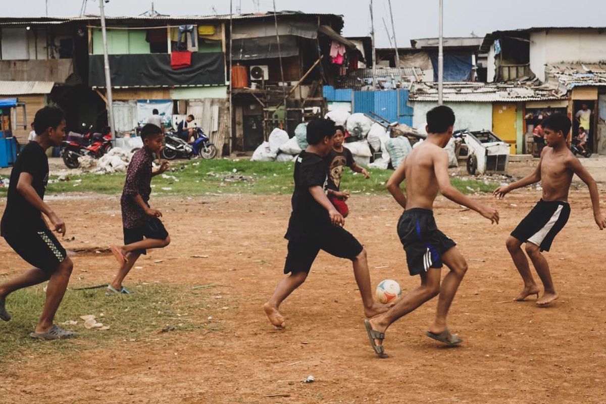 Anak-anak Kampung Muka, Kelurahan Ancol, Kecamatan Pademangan, Jakarta Utara bermain sepak bola di area perkampungan pada Minggu (5/4/2020). Saat ini, Indonesia menghadapi wabah pandemi corona dan mengharuskan setiap orang melakukan pembatasan fisik (physical distancing) untuk mencegah penularan. Pemerintah menyatakan per Senin (6/4/2020) sore, ada 2.491 orang positif corona, 192 orang sembuh, dan 209 orang sembuh.