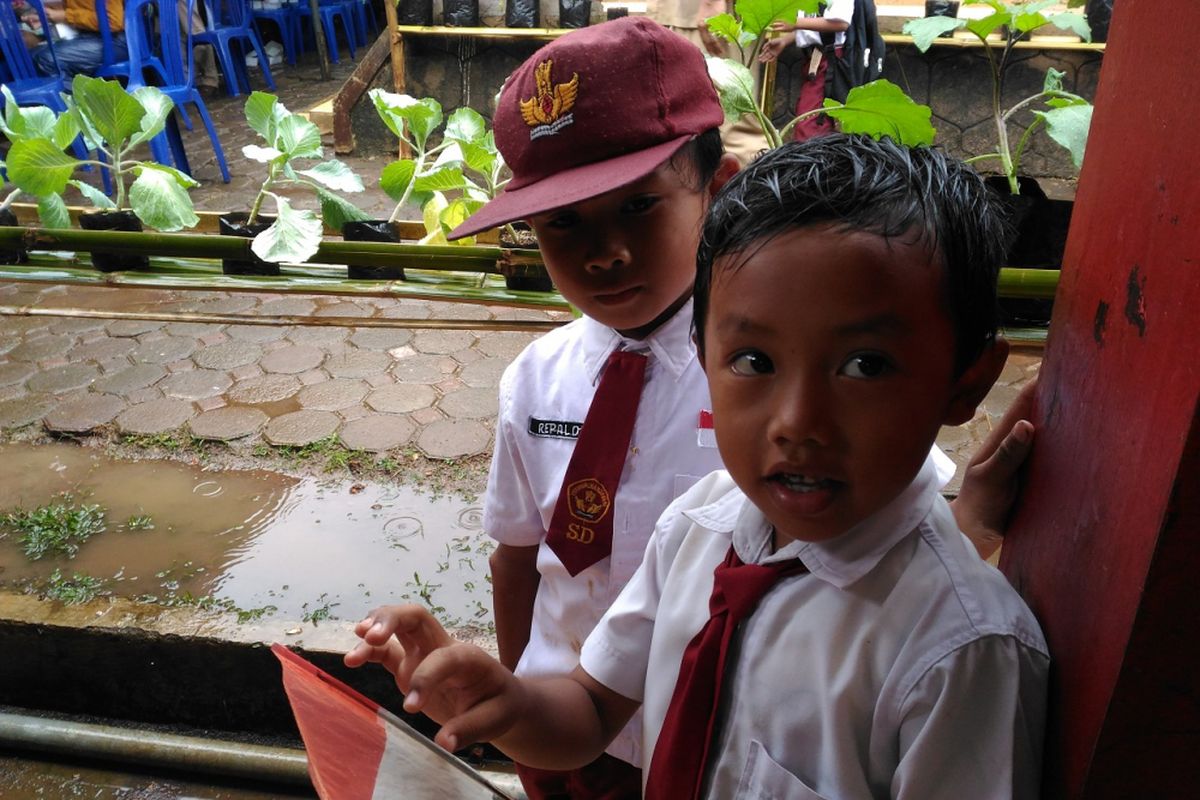 Dua siswa SD Wanajaya di Desa Cikancana, Kecamatan Sukaresmi, Kabupaten Cianjur berdiri di dekat kebun sekolah yang diberikan Badan Ketahanan Pangan, Kementerian Pertanian terkait program Bantuan Kemiskinan Rakyat Sejahtera. Program itu diresmikan Menteri Pertanian, Andi Amran Sulaiman, di Desa Cikancana, Kecamatan Sukaresmi, Kabupaten Cianjur, Senin (23/4/2018).