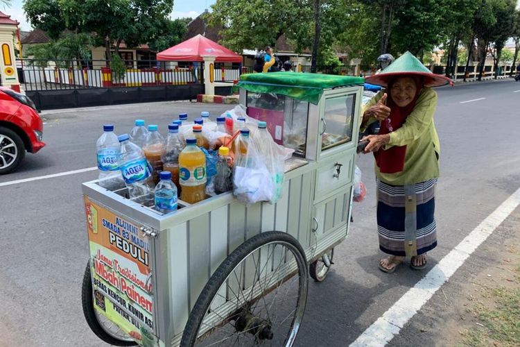 DORONG GEROBAK—Kendati usianya sudah uzur, tak menyurutkan Mbah Painem untuk terus berjuang bertahan hidup meski harus mendorong gerobak jualan keliling jamu tradisional di tengah panas teriknya jalanan Kota Madiun, Jawa Timur, Kamis (30/9/2021).