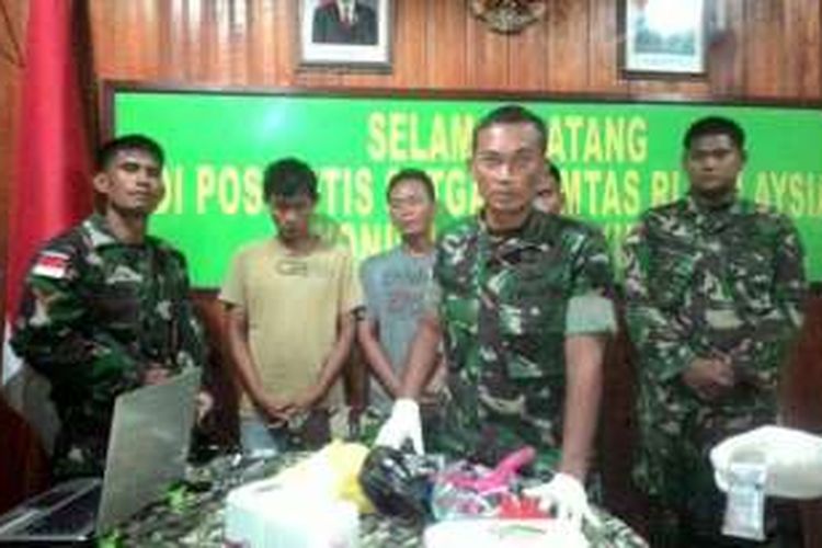 Dua tersangka beserta barang bukti 2 kilogram sabu yang diamankan Satgas Pamtas Yonif 144/JY saat di amankan di Pos Kotis Entikong. 