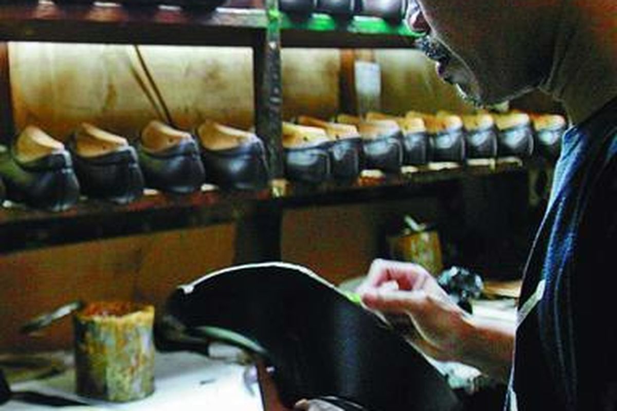 Perajin memproduksi sepatu di bengkel produksi skala kecil di kawasan Cakung, Jakarta Timur, Minggu (3/1). Pengusaha sepatu skala kecil mengharapkan dukungan dari pemerintah untuk memproteksi produk mereka dari serbuan produk China setelah Perjanjian Perdagangan Bebas atau FTA (Free Trade Agreement) ASEAN-China mulai efektif per 1 Januari 2010.