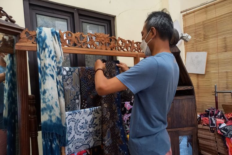 Eko Haryanto sedang menata kain batik karyanya di gerai Cinta Batik Semarang