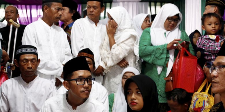 Pasangan pengantin mengikuti nikah massal yang diselenggarakan Partai Kebangkitan Bangsa di KUA Menteng, Jakarta Pusat, Jumat (25/8/2017). Sebanyak 103 pasangan pengantin mengikuti acara ini.