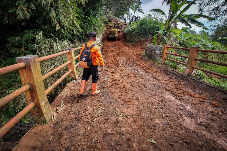 Proses evakuasi material longsor yang tutu jalan penghubung dua kecamatan di Bandung Barat.
