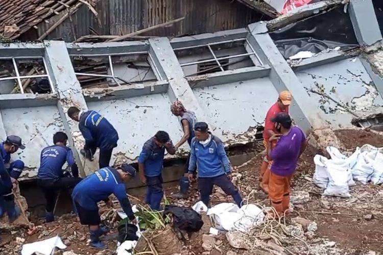 Petugas gabungan dari PPSU dan Suku Dinas SDA Jakarta Selatan menangani tembok roboh dan menimpa rumah milik warga Gang Melati RT 010 RW 03 Bangka, Mampang Prapatan, Jakarta Selatan pada Senin (22/2/2021).