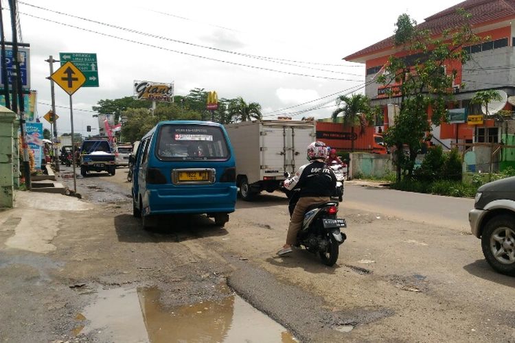 Kondisi Jalan Raya Jakarta-Bogor di Perempatan Gaplek, Tangsel yang penuh lubang. Semua kendaraan melambat untuk menghindari lubang-lubang berdiameter 20-30 cm dengan kedalaman 10-20 cm. Foto diambil Selasa (30/1/2018).