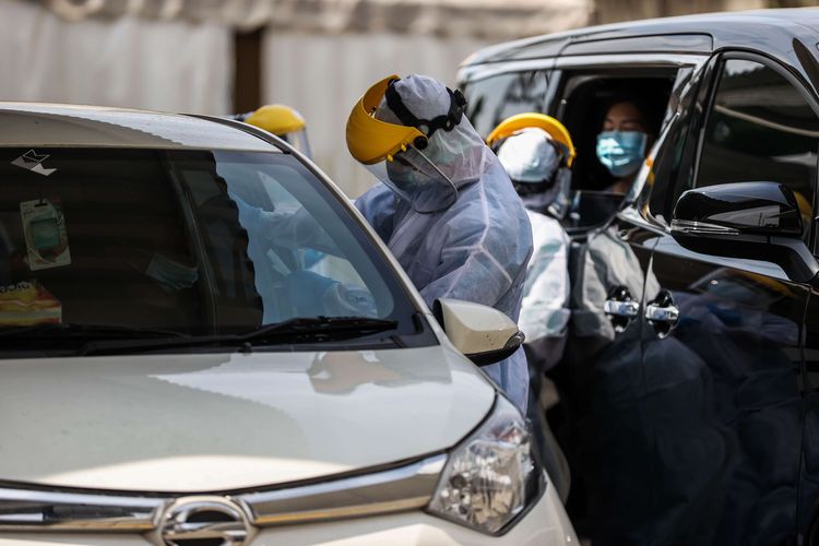 Petugas kesehatan melakukan tes usap reaksi rantai polimerase (PCR) secara drive thru kepada warga di halaman GSI Lab di Jakarta Selatan, Selasa (23/2/2021). Dengan adanya kerja sama senilai 100.000 dollar AS ini diharapkan dapat membantu pemerintah dalam penanganan Covid-19, khususnya untuk mempercepat tracking kasus positif Covid-19 di masyarakat.