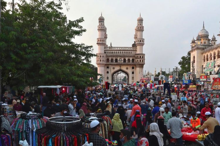 Warga berkerumun di pasar di depan masjid Charminar yang terkenal di bulan suci Ramadan di Hyderabad, India, mengabaikan protokol kesehatan, Kamis, 6 Mei 2021.