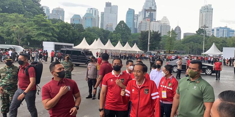 Presiden RI Joko Widodo mengenakan jaket merah bergaris putih di lengan. Jokowi datang ke Stadion Gelora Bung Karno Jakarta untuk menyaksikan laga Indonesia vs Kamboja dalam penyisihan Grup A Piala AFF 2022, Jumat (23/12/2022).