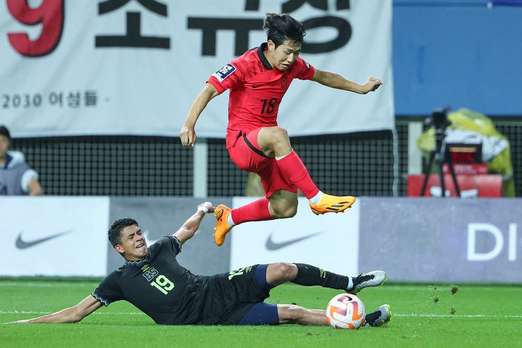 Pemain Korea Selatan, Lee Kang-in (atas), menghindari terjangan pemain El Salvador, Kevin Reyes, dalam pertandingan persahabatan di Stadion Daejeon di Daejeon, 20 Juni 2023. Lee dikabarkan terlibat keributan dengan Son Heung-min saat tampil di Piala Asia 2023.