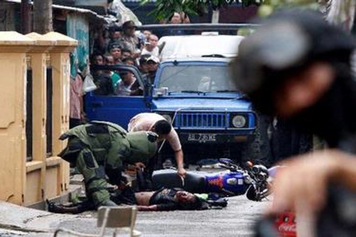 Anggota Densus 88 memeriksa jenazah yang diduga anggota teroris yang ditembak dalam penggerebekan di Gang Asem, Kelurahan Pamulang Barat, Kecamatan Pamulang, Tangerang Selatan, Selasa (9/3/2010).