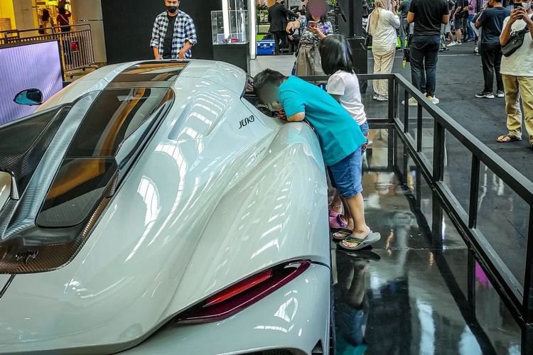 Pengunjung melewati pagar pembatas untuk berfoto dengan hypercar Koenigsegg Jesko yang dipamerkan di TDA Luxury Autoshow