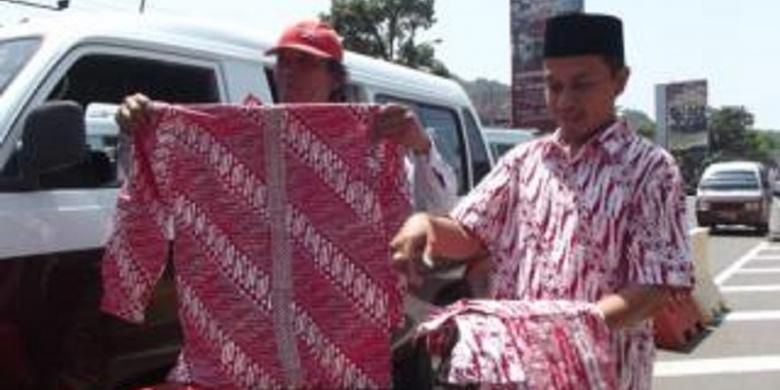 Memperingati Hari Batik Nasional, pengusaha sekaligus pemerhati batik membagikan baju batik secara gratis kepada para sopir dan tukang parkir di ruas jalan utama di Kabupaten Magelang, Jawa Tengah, Rabu (2/10/2013).